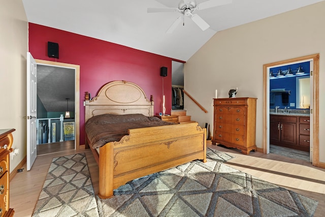 bedroom with lofted ceiling, sink, ceiling fan, light wood-type flooring, and connected bathroom