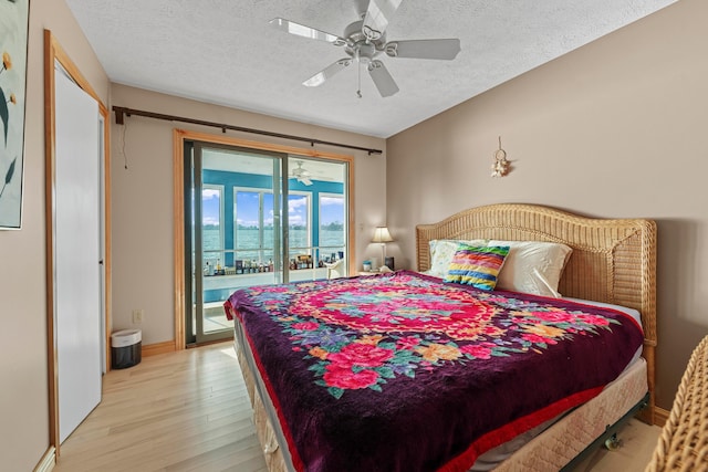 bedroom featuring ceiling fan, access to exterior, light wood-type flooring, and a textured ceiling