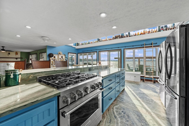 kitchen featuring ceiling fan, a textured ceiling, and appliances with stainless steel finishes