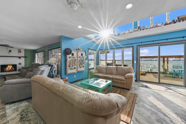 living room featuring a fireplace and a water view