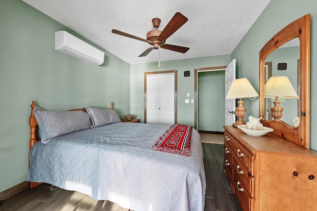 bedroom with ceiling fan, a closet, dark wood-type flooring, and a wall mounted air conditioner