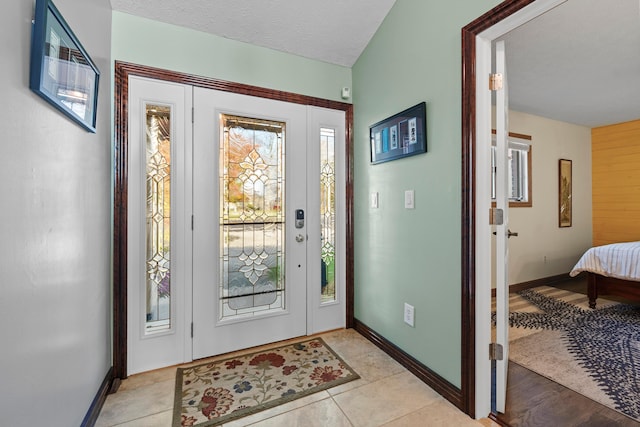 foyer entrance featuring light tile patterned floors and a textured ceiling