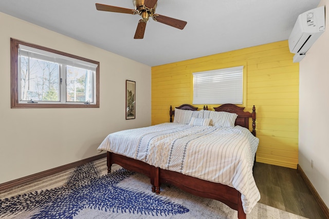 bedroom with a wall unit AC, ceiling fan, wooden walls, and dark hardwood / wood-style floors