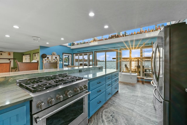 kitchen with stainless steel appliances, blue cabinets, and a water view