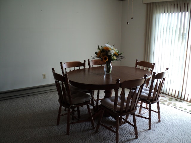 carpeted dining room with baseboard heating