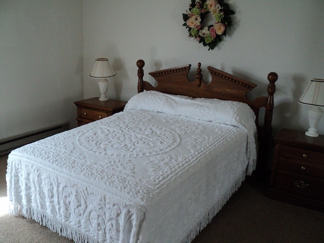 carpeted bedroom featuring a baseboard heating unit