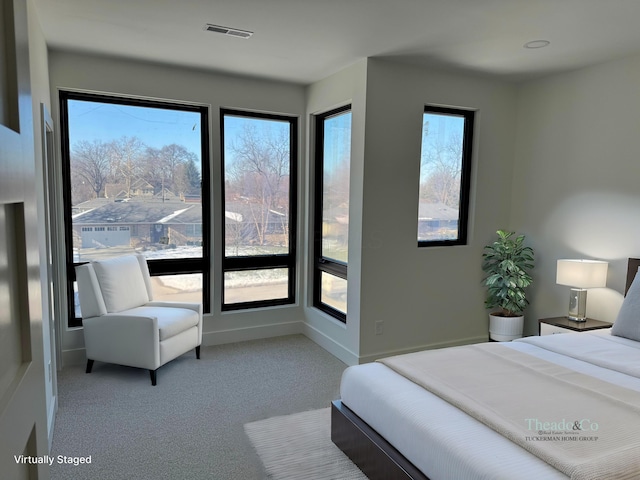 carpeted bedroom featuring baseboards and visible vents