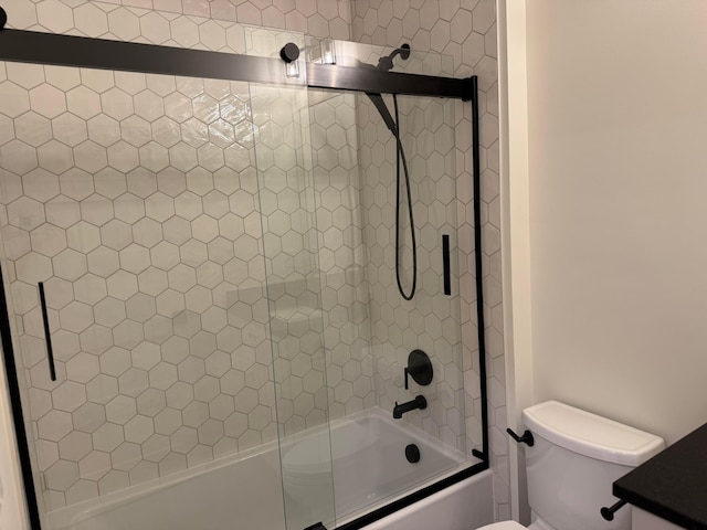 bathroom with combined bath / shower with glass door and toilet