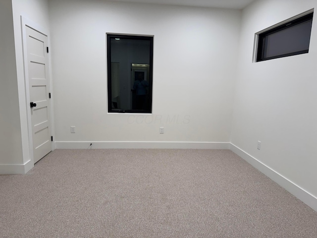 unfurnished room with carpet floors and baseboards