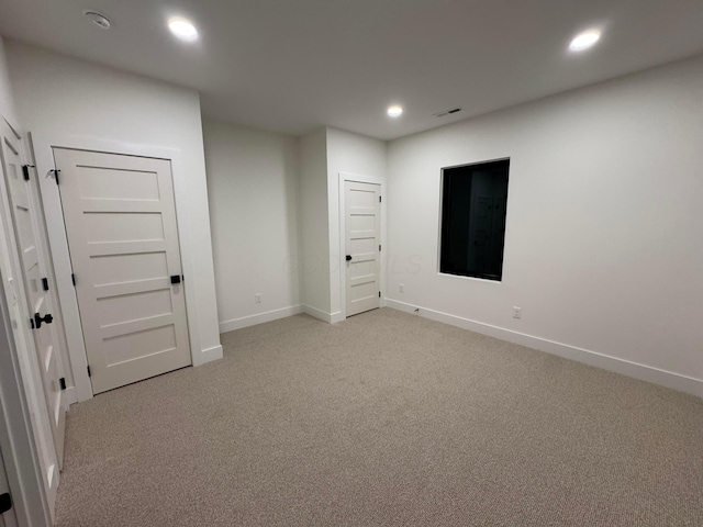 empty room featuring light carpet, baseboards, visible vents, and recessed lighting