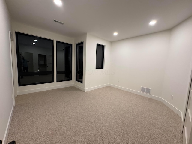 spare room with light carpet, baseboards, visible vents, and recessed lighting