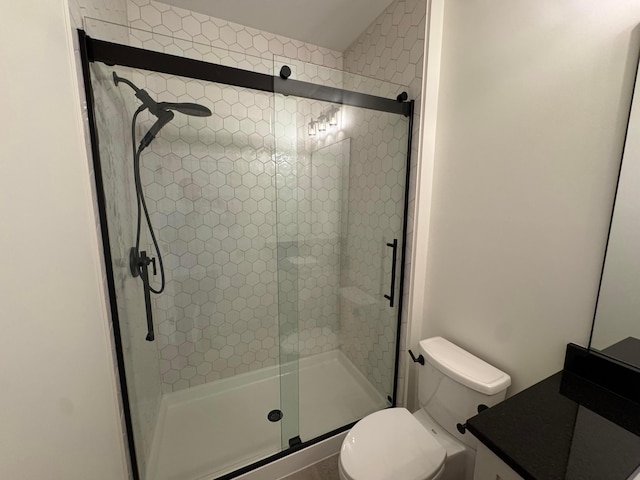 bathroom featuring a stall shower, vanity, and toilet