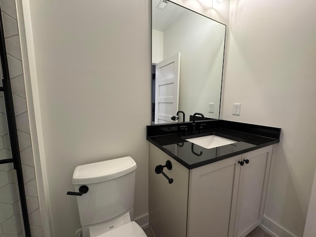 bathroom featuring vanity, toilet, and baseboards