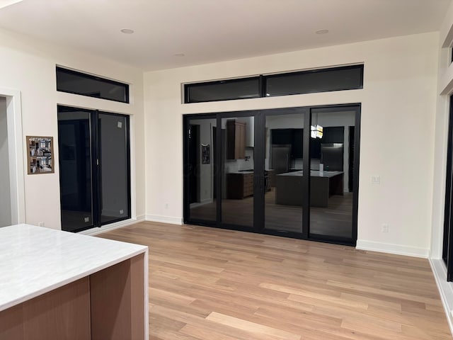 kitchen featuring baseboards, light countertops, and light wood-style floors