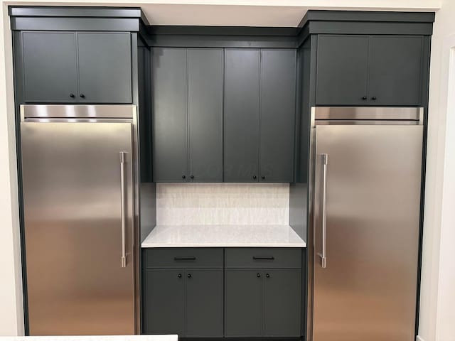 kitchen with gray cabinets, stainless steel built in refrigerator, light countertops, and tasteful backsplash