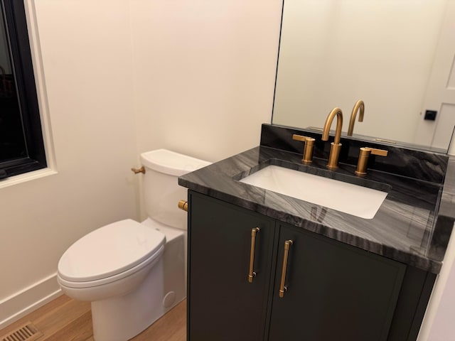 bathroom featuring visible vents, vanity, toilet, and wood finished floors