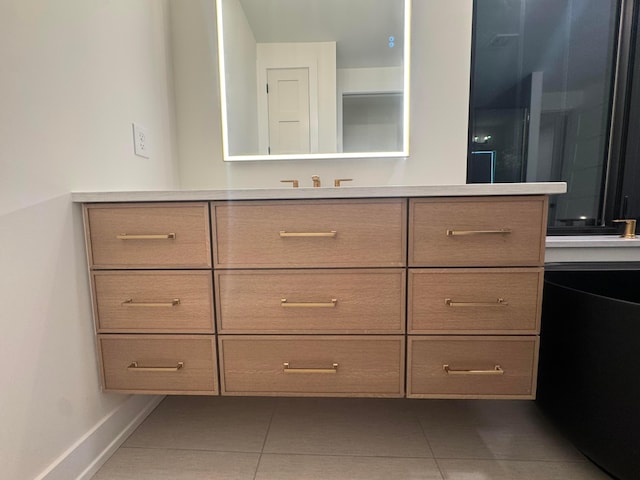 bathroom featuring vanity, baseboards, and tile patterned floors