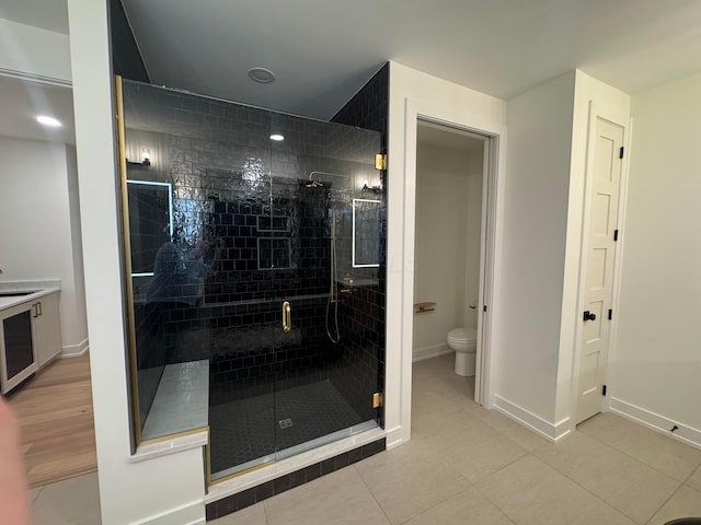 bathroom with toilet, beverage cooler, baseboards, a shower stall, and tile patterned floors