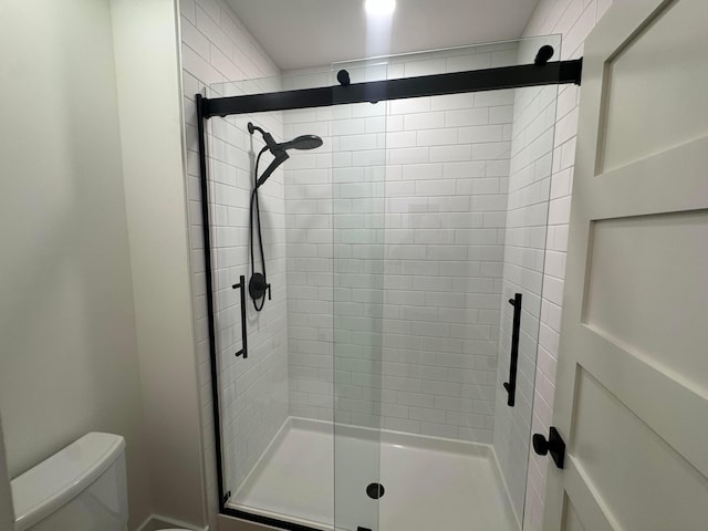 bathroom with a stall shower and toilet