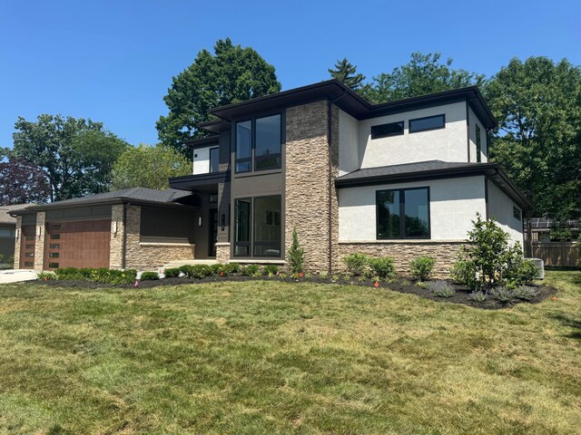 3130 S Dorchester Rd, Columbus, OH 43221 - view of front of home with stone siding, stucco siding, an attached garage, and a front lawn