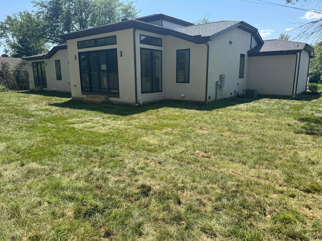 3130 S Dorchester Rd, Columbus, OH 43221 - rear view of house featuring stucco siding, a lawn, and roof with shingles