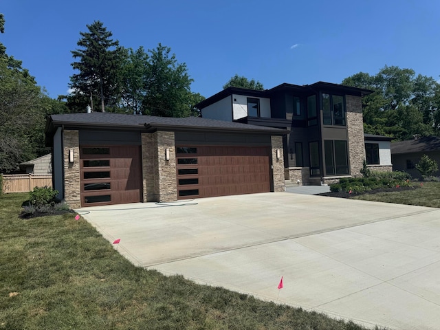 3130 S Dorchester Rd, Columbus, OH 43221 - view of front facade featuring stone siding, a garage, driveway, and a front lawn