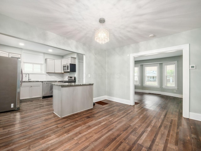 kitchen featuring appliances with stainless steel finishes, dark hardwood / wood-style flooring, white cabinetry, and pendant lighting