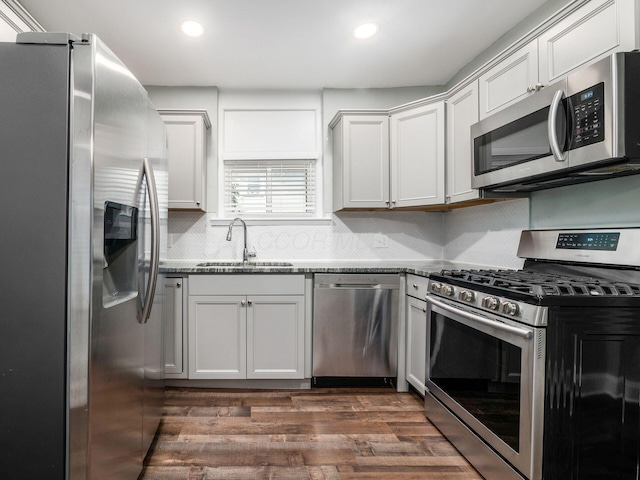 kitchen with sink, stainless steel appliances, dark hardwood / wood-style flooring, decorative backsplash, and white cabinets