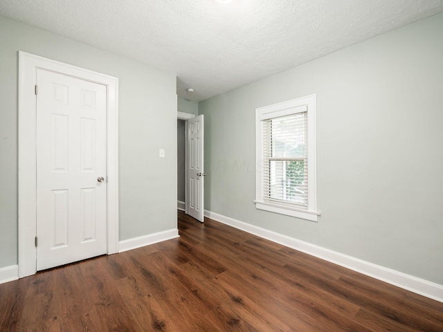 unfurnished bedroom featuring dark hardwood / wood-style floors and a textured ceiling