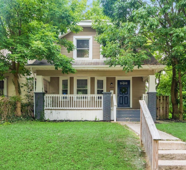 view of front of house featuring covered porch and a front yard