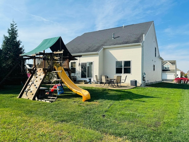 rear view of house featuring a playground, a lawn, and a patio