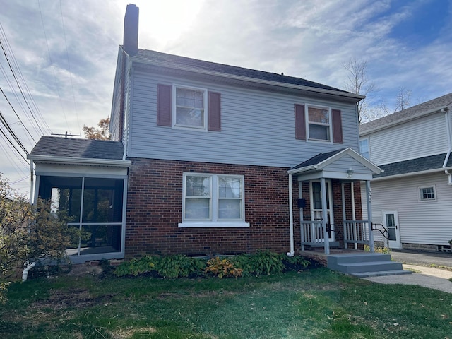 view of property with a sunroom and a front lawn