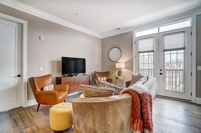 living room featuring ornamental molding and light wood-type flooring