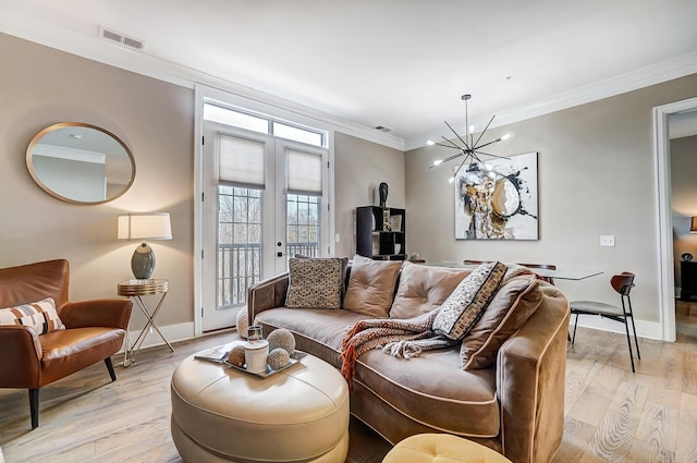 living room featuring crown molding, french doors, an inviting chandelier, and light wood-type flooring