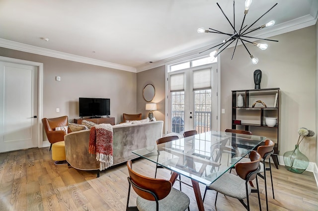 dining space with a chandelier, french doors, light hardwood / wood-style flooring, and ornamental molding