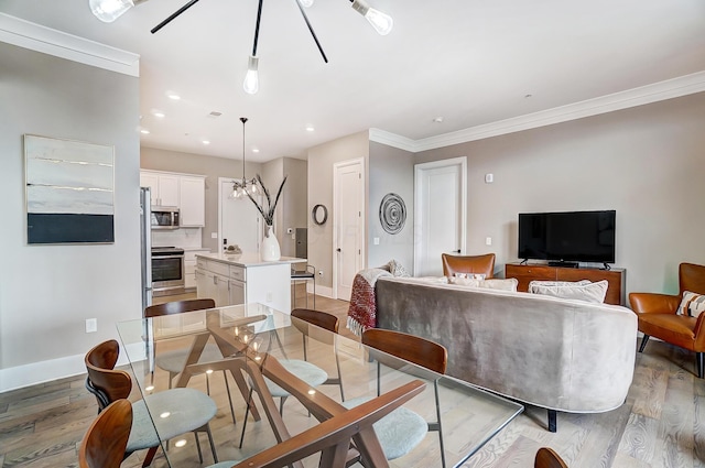 dining space featuring hardwood / wood-style floors and ornamental molding