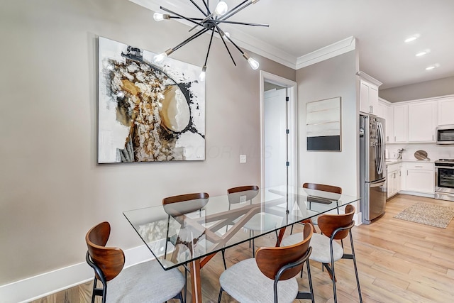 dining room with light wood-type flooring, ornamental molding, and an inviting chandelier