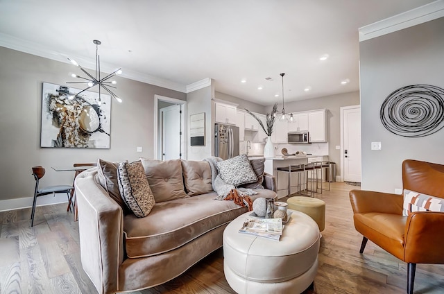 living room with light hardwood / wood-style floors, a notable chandelier, and ornamental molding