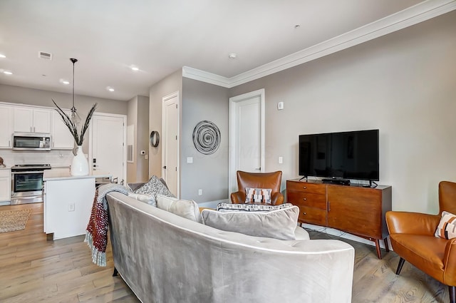 living room featuring light hardwood / wood-style floors and crown molding