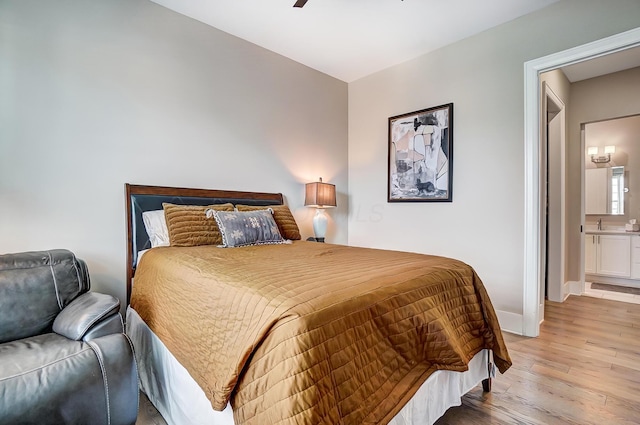 bedroom with ensuite bathroom, ceiling fan, and light hardwood / wood-style floors