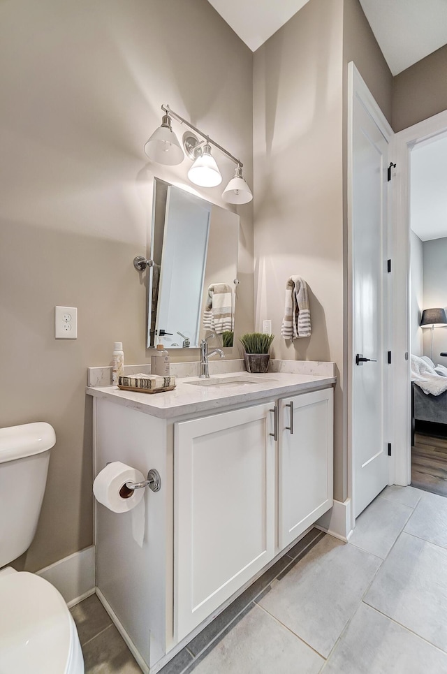 bathroom with tile patterned flooring, vanity, and toilet