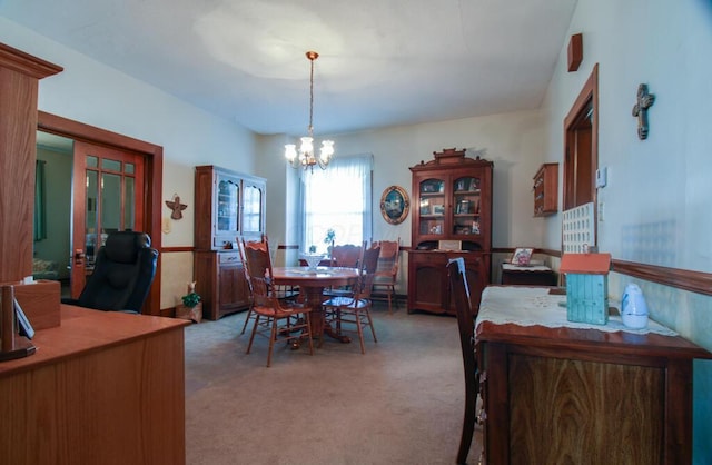 carpeted dining room with a chandelier