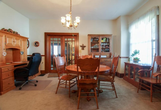 dining space featuring a chandelier and light colored carpet