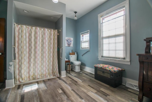 bathroom with a shower with shower curtain, toilet, and wood-type flooring