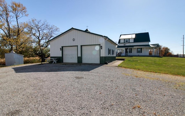 view of front of house featuring a shed, a front lawn, and a garage