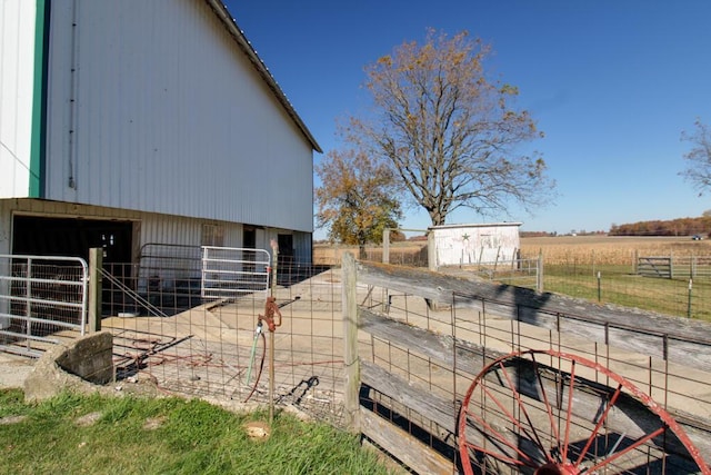 view of home's exterior with a rural view and an outdoor structure