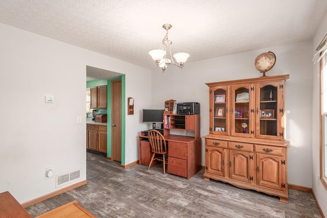 office area with hardwood / wood-style floors, a textured ceiling, and a notable chandelier