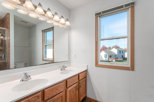 bathroom featuring vanity, toilet, and walk in shower