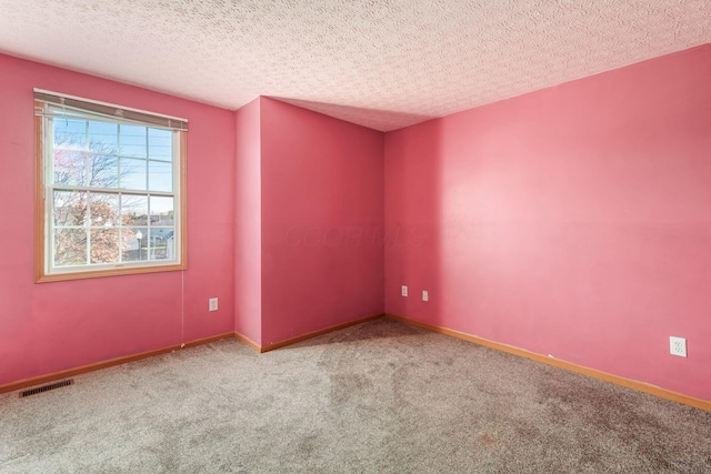 empty room featuring carpet floors and a textured ceiling