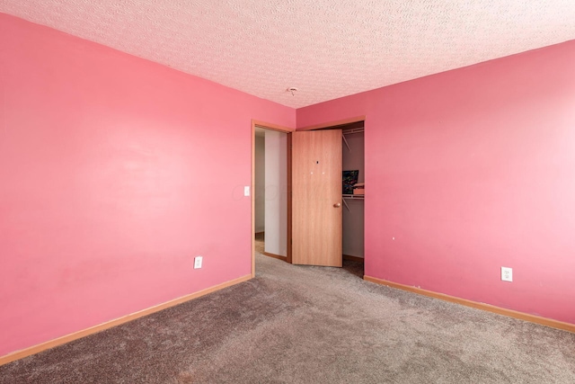 carpeted empty room featuring a textured ceiling